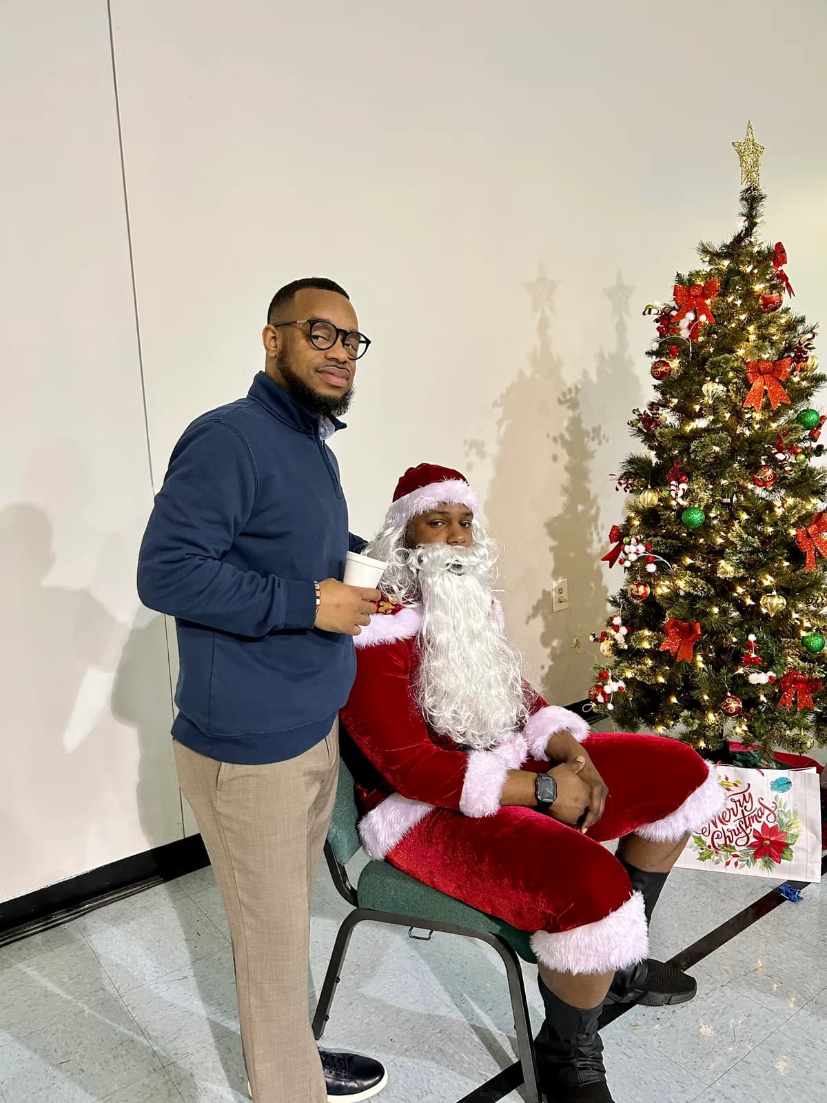 A church member with Santa beside the Christmas tree