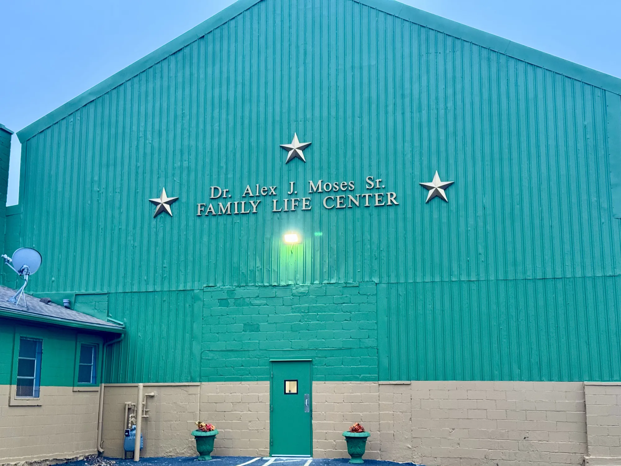 The green Dr. Alex J. Moses Sr. Family Life Center, with three gold stars on the front