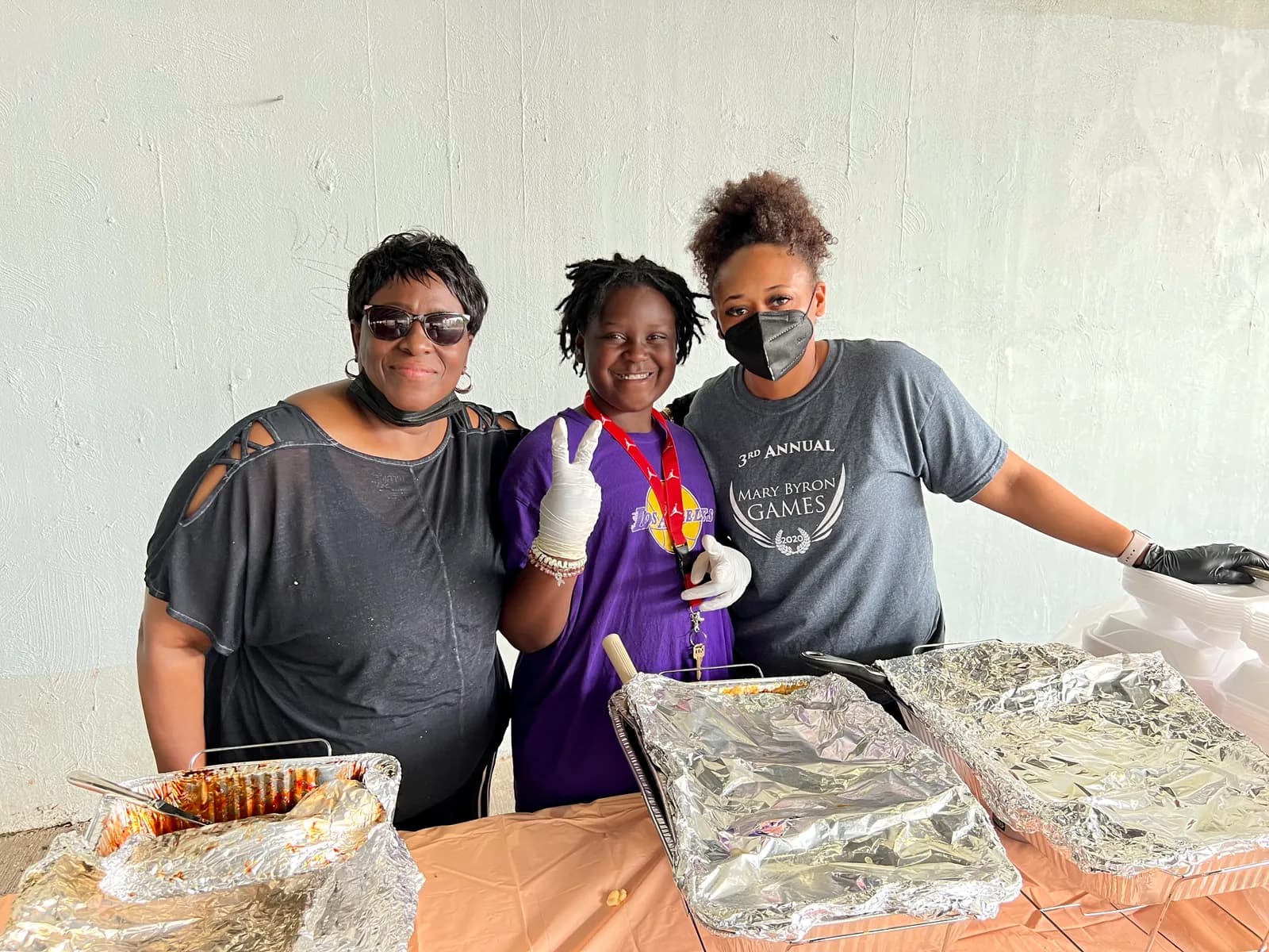 Three volunteers with trays of food